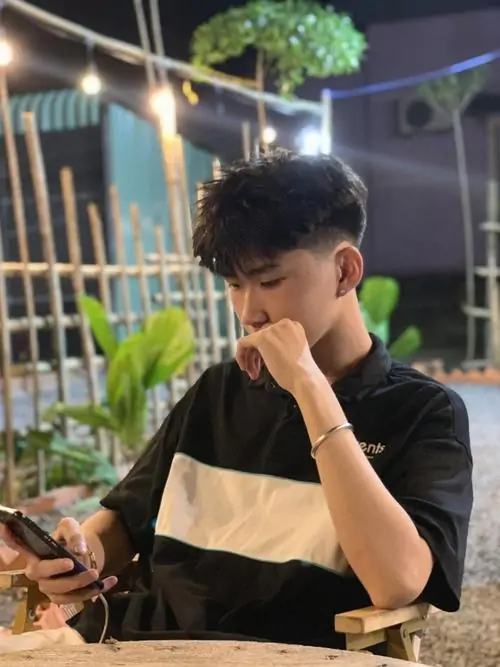 Góc chụp từ dưới lên bắt trọn vẻ nam tính của hình trai đẹp bí ẩn mặc áo thun phối màu đang ngồi suy tư lúc đêm muộn.