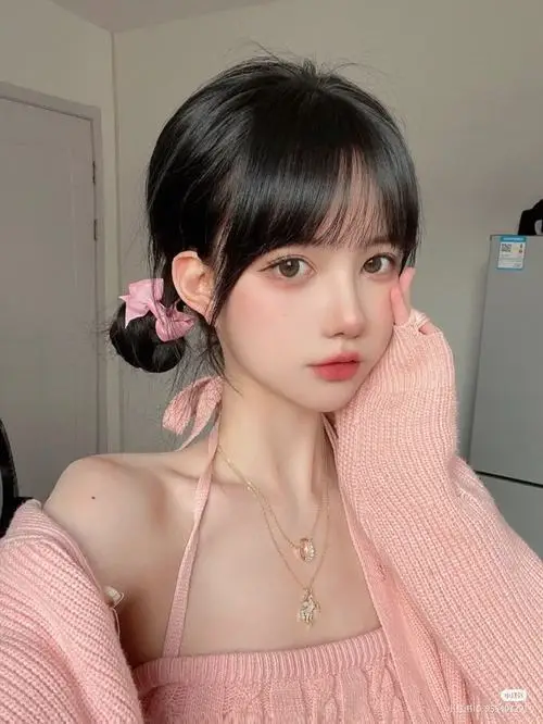Thiếu nữ buộc tóc hai bên bằng ruy băng hồng diện chiếc áo len hồng phấn nhẹ nhàng tựa lưng vào bức tường trắng khoe nét đẹp trong trẻo ngọt ngào