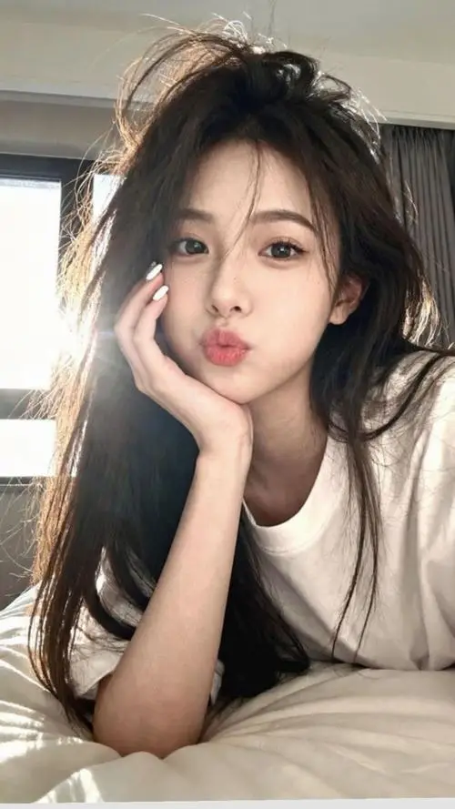 Ảnh thiếu nữ đẹp nằm lười trên giường nhẹ nhàng tựa cằm lên tay với ánh mắt mơ màng đầy cuốn hút trong nắng chiều buông nhẹ xuống phòng