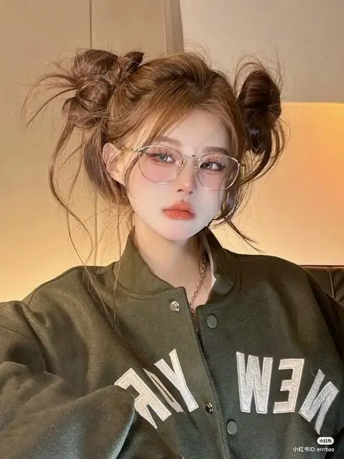 Ảnh cô gái đẹp búi tóc hai bên tinh nghịch đeo kính gọng tròn diện chiếc áo khoác bomber màu xanh rêu mang đậm phong cách đường phố cá tính