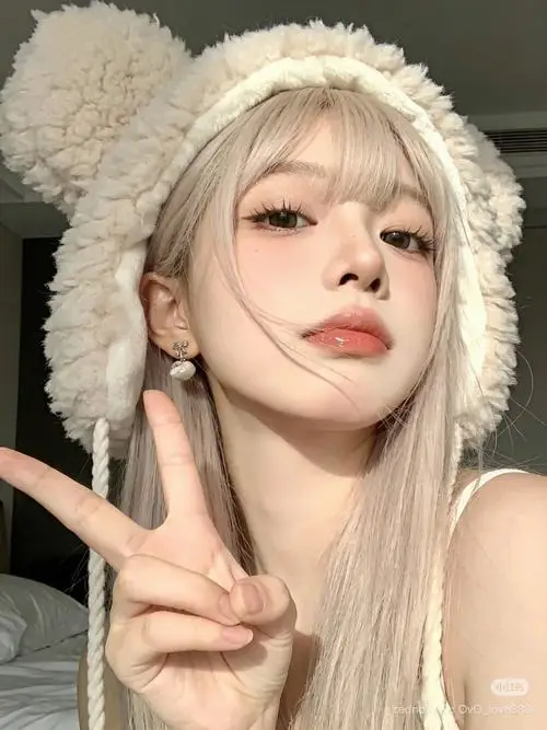 Mỹ nhân diện mũ lông cừu màu trắng sữa ấm áp đang giơ hai ngón tay tạo dáng đáng yêu trước ống kính máy ảnh trong ngày đông giá lạnh