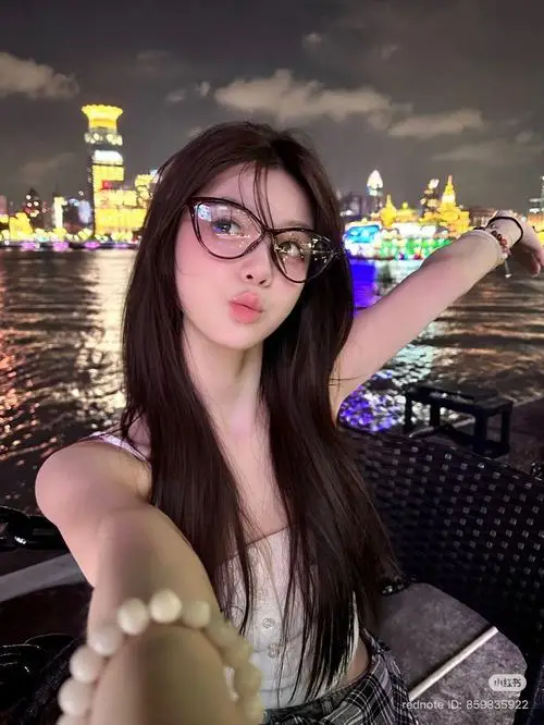 Cô gái đeo kính cận nở nụ cười rạng rỡ khi đi dạo phố vào ban đêm dưới ánh đèn màu lung linh của thành thị hiện đại