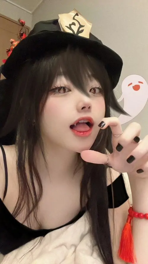 Cô gái đội mũ tạo dáng cầm điện thoại trước gương, áo viền đỏ và biểu cảm tinh nghịch gợi cảm giác ảnh gái đẹp phây búc tóp tóp