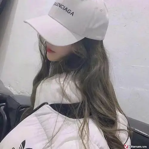 Mũ lưỡi trai trắng kéo thấp tạo ảnh hot girl giấu mặt, mái tóc dài phủ vai và áo trễ vai sáng màu nhìn rất mềm