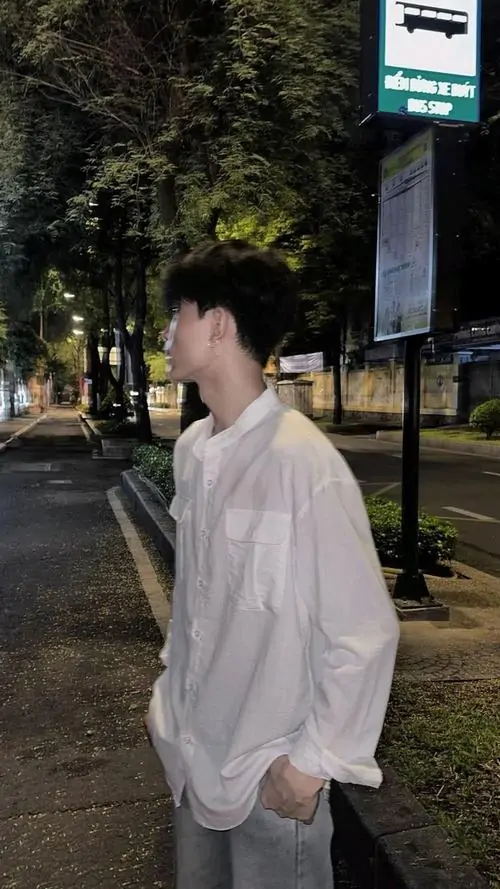 Trang phục thể thao năng động màu xanh thẫm ôm sát vóc dáng săn chắc của thanh niên đang tập chạy bộ trong công viên buổi sớm.