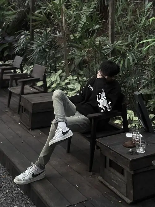 Góc nghiêng xuất sắc của trai đẹp giấu mặt bí ẩn mặc áo hoodie xám đang đeo tai nghe đứng chờ tàu điện ngầm đông đúc.