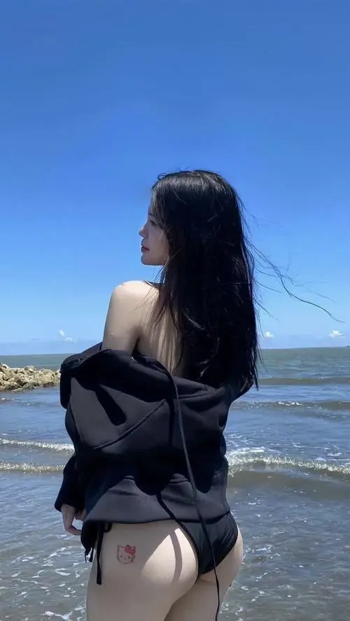 Cô gái tạo dáng dưới hàng dừa resort, bikini đen tối giản phối kính mát thời trang giúp tổng thể gọn gàng và sang hơn