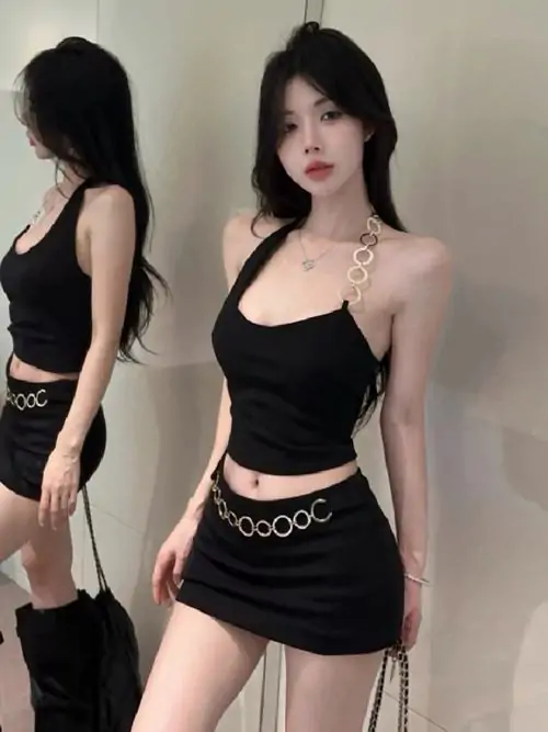 Bên vách tường uốn cong, cô nàng mặc đầm đen ôm sát cúi nhẹ đầu, mái tóc nâu dài tạo cảm giác trầm