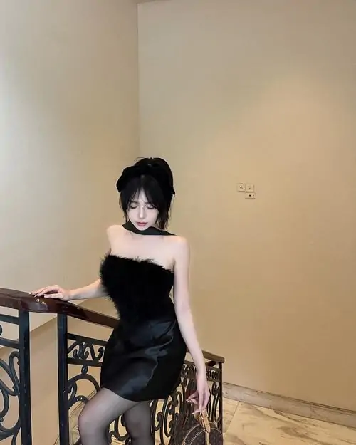 Tia flash che gương mặt cô nàng ngồi trên sàn, váy đen ngắn và mái tóc tối màu tạo tông ảnh tối giản