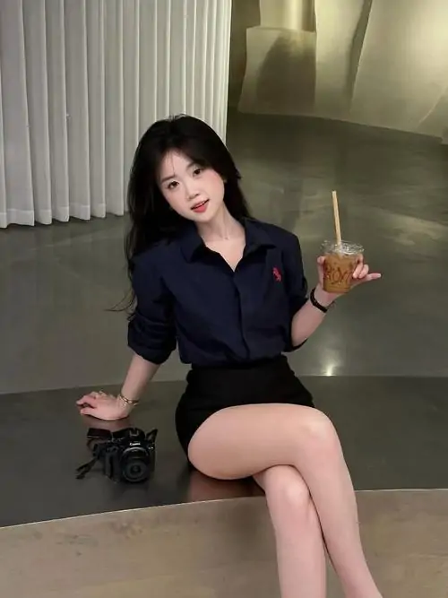 Gái xinh mặc váy ngắn đen chụp selfie qua gương ngoài trời, áo trắng rộng tay và chân váy ôm tạo vẻ năng động