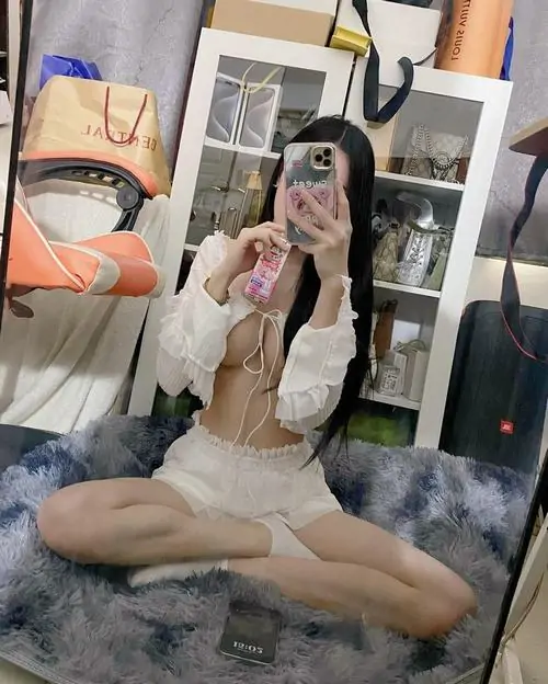Gái xinh mặc đồ ngủ phong cách Vintage ngồi bên bàn trang điểm, mái tóc xoăn nhẹ và ánh đèn ngủ vàng ấm