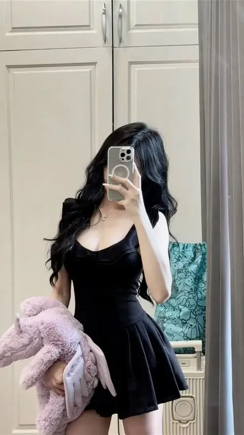 Trước gương phòng ngủ, ảnh phái đẹp mặc đồ đen gợi cảm thanh lịch hiện lên với váy xòe, tóc dài và dáng chụp kín đáo