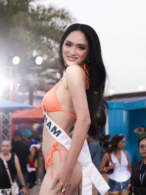 Nền trời xanh cùng hàng dừa tạo cảm giác nghỉ dưỡng, nàng hậu thả dáng trong bikini tối màu, lưng trần thanh thoát và dáng đi nhẹ