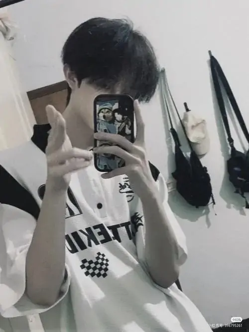 Góc máy selfie chụp từ dưới lên bắt trọn nụ cười mỉm nhẹ nhàng của một trai đẹp mặc áo thun trắng có in họa tiết chữ đen đơn giản cá tính